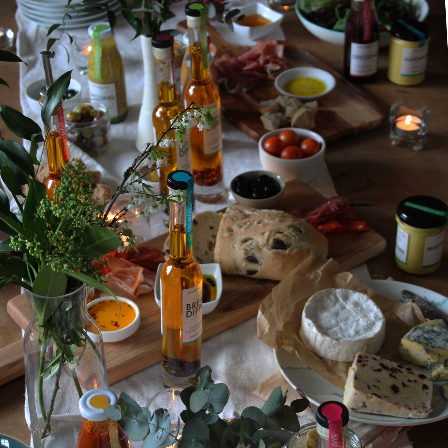 A filled grazing table with breads, oils, cheese and charcuterie