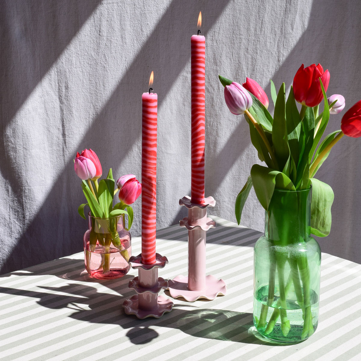 Two pink dinner candles in pink candlesticks